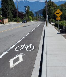 A road and bike lane with mountains in the distance.