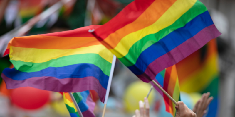 hands holding pride flags