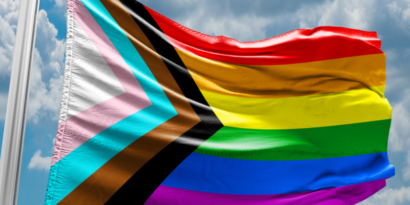 The pride progress flag blowing in the breeze.